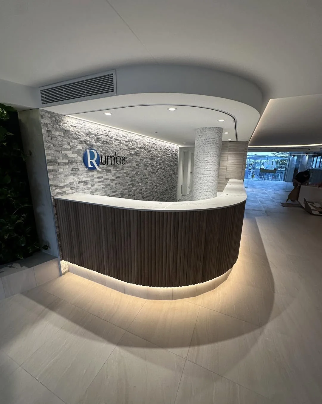A commercial reception, freshly painted, with a curved timber desk