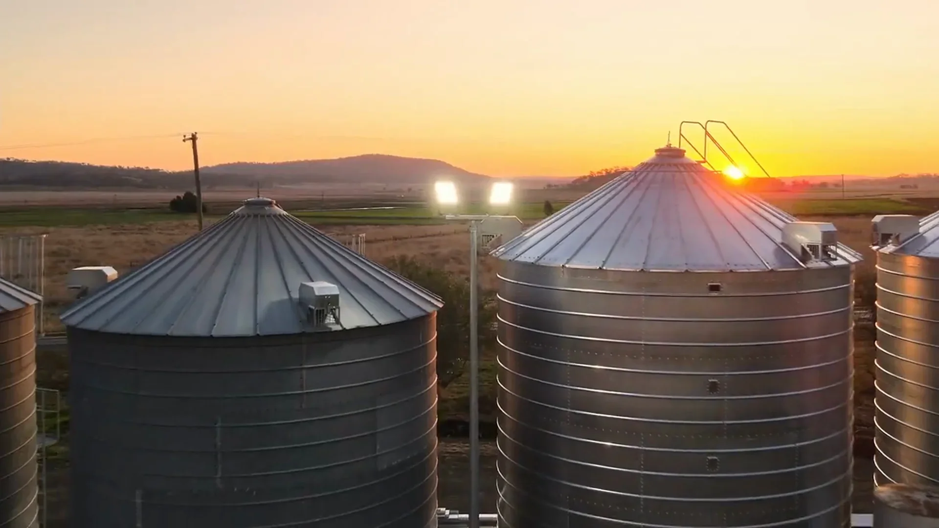 A row of grain silos at sunset